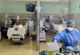 Medical worker wearing a protective mask and suit treats patients suffering from coronavirus disease