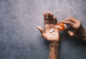 Man's hand with pills spilled out of the container